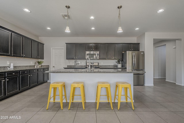22463 E Desert Spoon Dr, Queen Creek, AZ 85142 - kitchen featuring stainless steel appliances, light tile patterned flooring, a sink, dark stone countertops, and recessed lighting