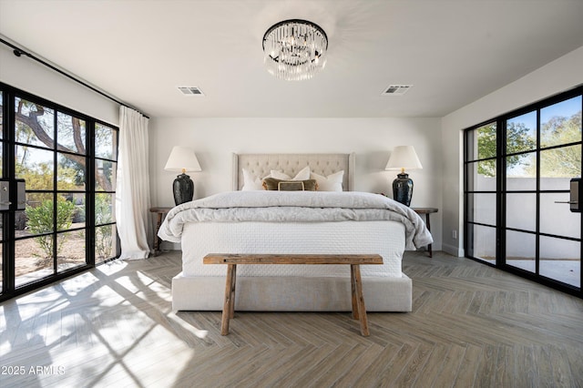 bedroom featuring light parquet flooring, a chandelier, and multiple windows