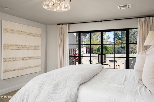 bedroom with wood-type flooring and an inviting chandelier