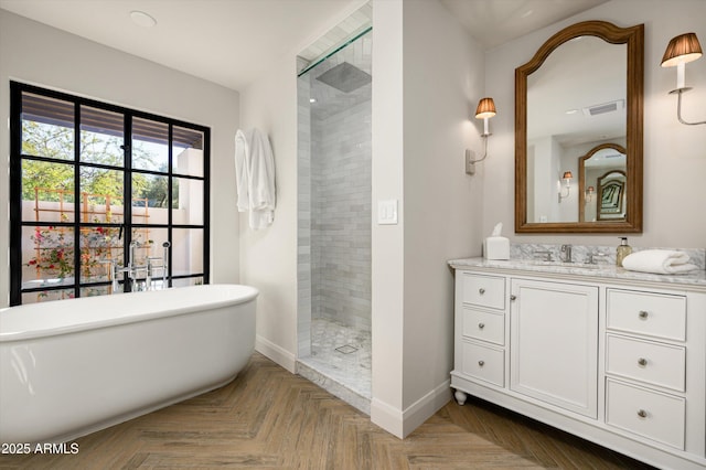 bathroom featuring parquet flooring, vanity, and plus walk in shower