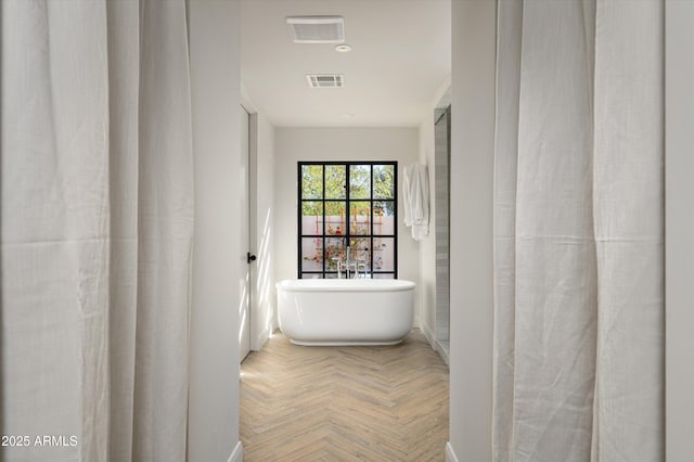 bathroom with parquet flooring and a tub