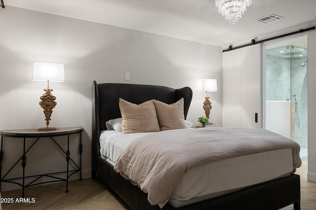 bedroom with parquet flooring, a barn door, and a chandelier