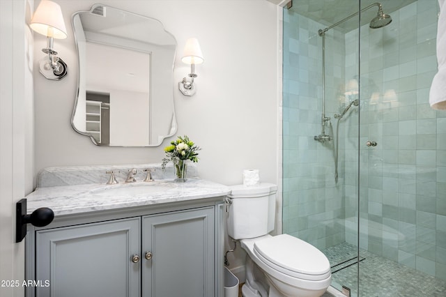 bathroom featuring vanity, an enclosed shower, and toilet