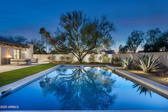 pool at dusk with a patio