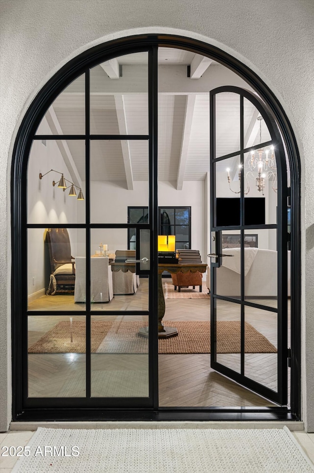 entryway featuring beamed ceiling and a notable chandelier