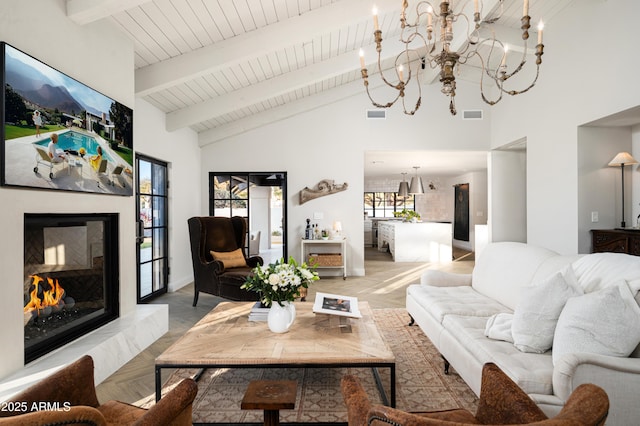 living room featuring beamed ceiling, high vaulted ceiling, light parquet floors, and a notable chandelier