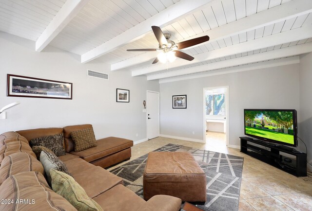 living room featuring beamed ceiling, ceiling fan, and light tile patterned floors