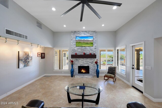 living room featuring light tile patterned flooring, a fireplace, track lighting, and ceiling fan