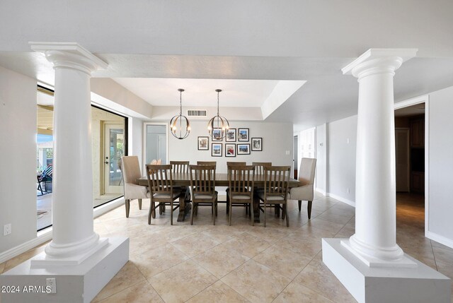 dining room with light tile patterned flooring, decorative columns, and a notable chandelier