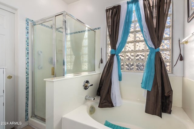 bathroom featuring shower with separate bathtub