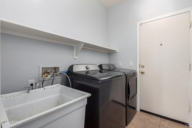 washroom featuring sink, washing machine and clothes dryer, and light tile patterned flooring