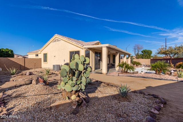 rear view of house featuring cooling unit and a patio area