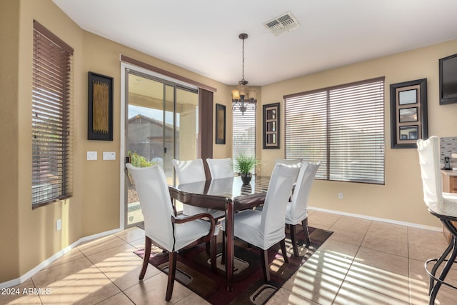 tiled dining space featuring a chandelier and a wealth of natural light