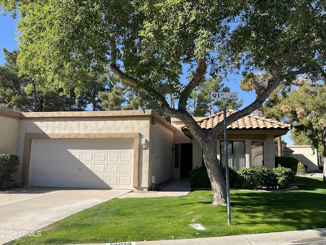 19014 N 91st Dr, Peoria, AZ 85382 - view of front of home featuring stucco siding, an attached garage, a front yard, driveway, and a tiled roof
