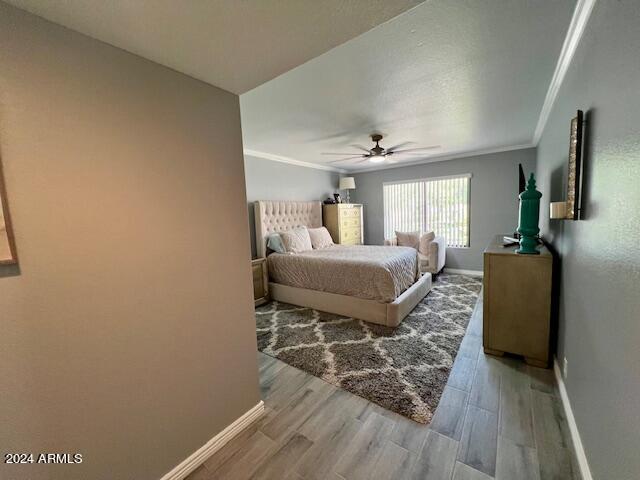 19014 N 91st Dr, Peoria, AZ 85382 - bedroom with baseboards, light wood-style flooring, ornamental molding, and a ceiling fan