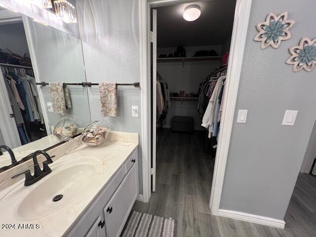 19014 N 91st Dr, Peoria, AZ 85382 - bathroom featuring wood finished floors, baseboards, vanity, and a walk in closet