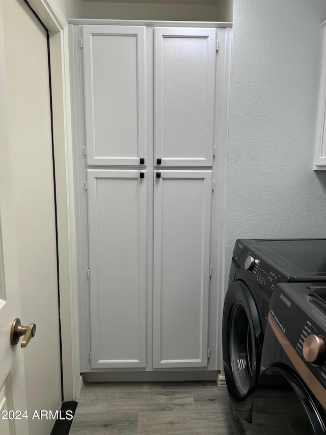 19014 N 91st Dr, Peoria, AZ 85382 - laundry room featuring washing machine and clothes dryer, cabinet space, and a textured wall