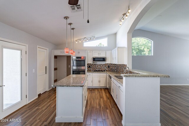 kitchen with lofted ceiling, light stone counters, dark hardwood / wood-style floors, and white cabinets