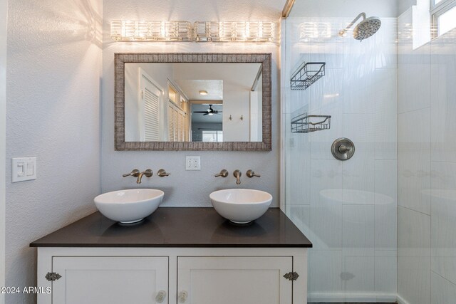 bathroom featuring a tile shower and vanity