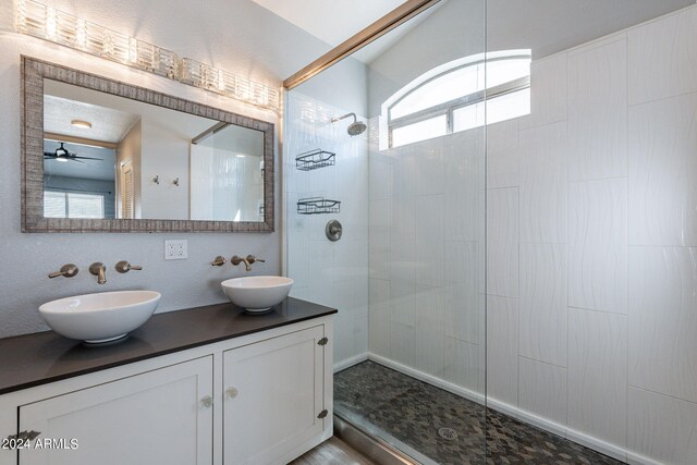 bathroom featuring vanity, a tile shower, plenty of natural light, and ceiling fan