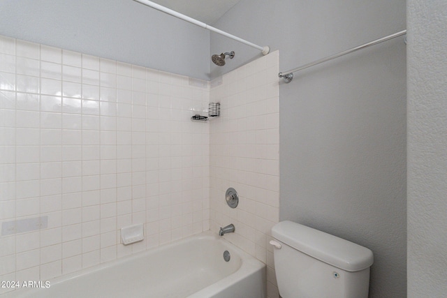 bathroom featuring tiled shower / bath combo and toilet