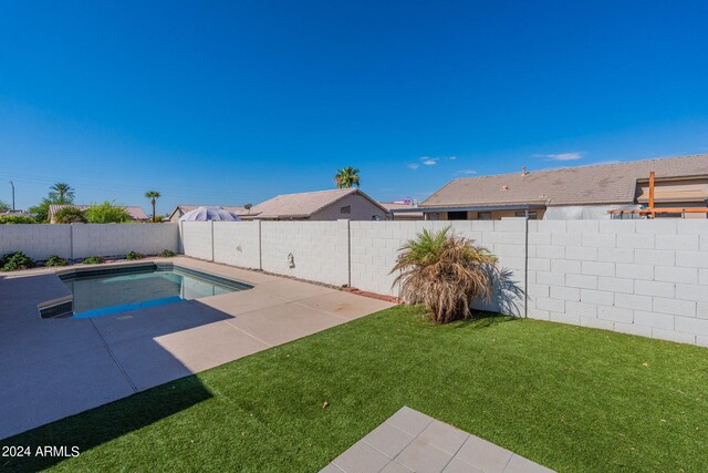 view of pool with a lawn and a patio