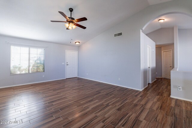 empty room with vaulted ceiling, ceiling fan, and dark hardwood / wood-style floors