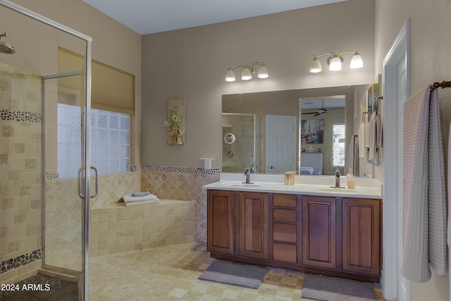 bathroom with ceiling fan, vanity, an enclosed shower, and tile walls