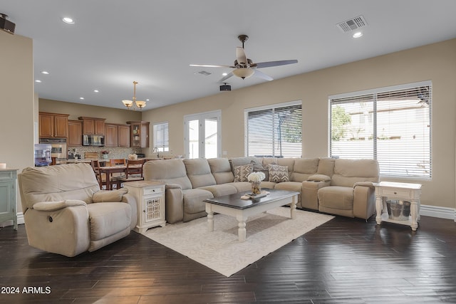 living room featuring ceiling fan with notable chandelier and dark hardwood / wood-style flooring