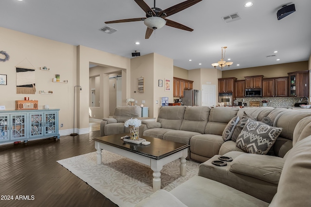 living room featuring dark wood-type flooring and ceiling fan with notable chandelier