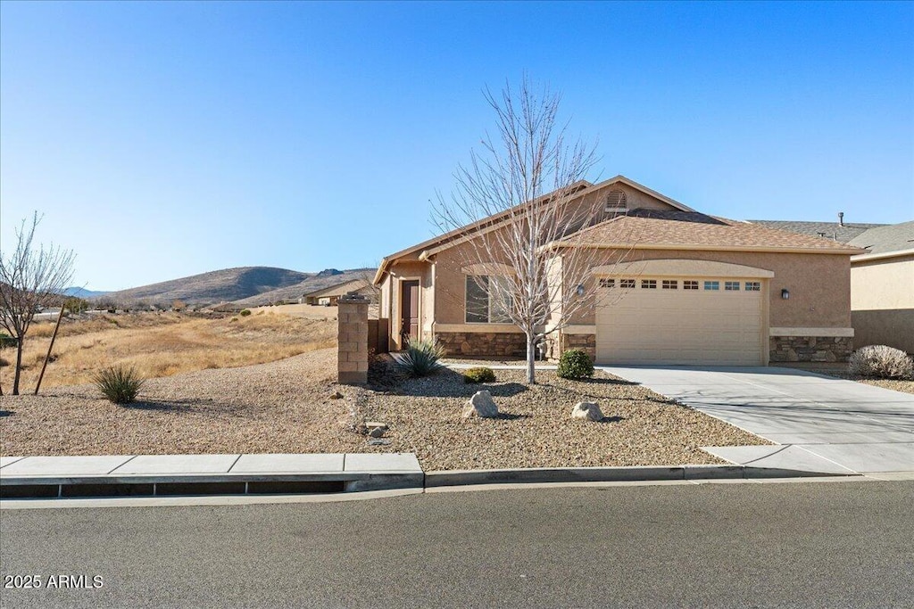 view of front facade featuring a garage and a mountain view