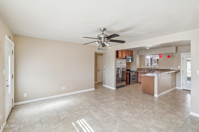 kitchen with ceiling fan, sink, stainless steel appliances, kitchen peninsula, and a breakfast bar