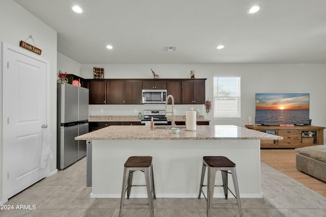 4714 W Nutmeg Ave, Coolidge, AZ 85128 - kitchen featuring stainless steel appliances, a kitchen breakfast bar, dark brown cabinets, recessed lighting, and light tile patterned flooring