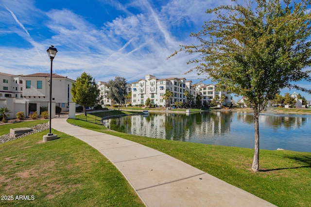 view of property's community featuring a water view, fence, and a yard