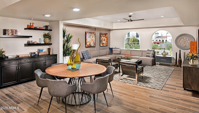 dining area featuring a tray ceiling, wood finish floors, a ceiling fan, and recessed lighting