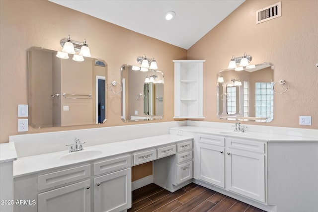 bathroom with vaulted ceiling and vanity