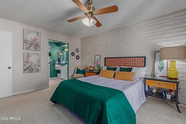 carpeted bedroom featuring a textured ceiling, a fireplace, ensuite bath, and ceiling fan