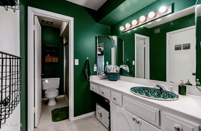 bathroom with tile patterned flooring, vanity, and toilet