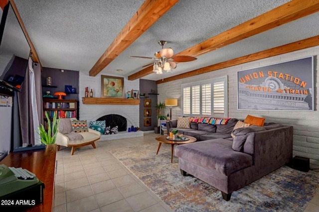 tiled living room featuring ceiling fan, a fireplace, and a textured ceiling