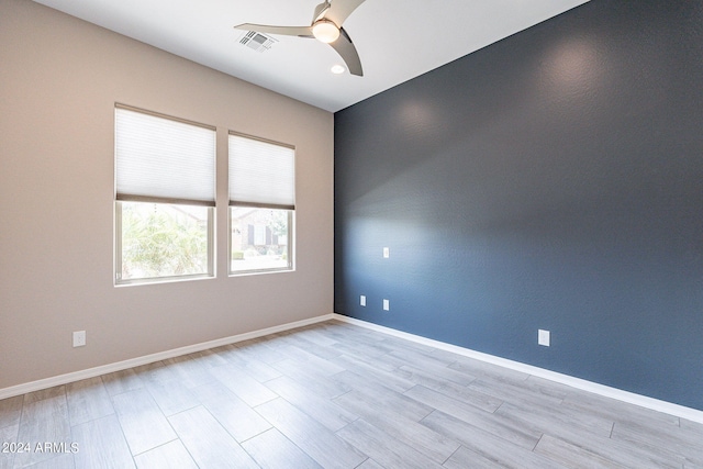 empty room with ceiling fan and light hardwood / wood-style flooring