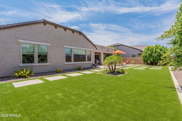 back of property with a yard and a patio