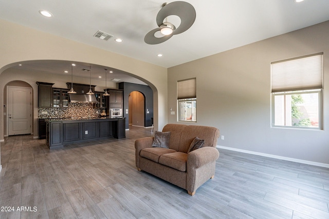 living room with ceiling fan and light hardwood / wood-style floors