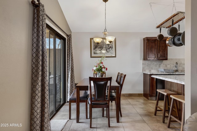 tiled dining area with lofted ceiling and a notable chandelier