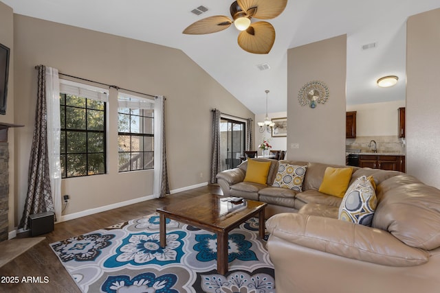 living room with sink, ceiling fan with notable chandelier, vaulted ceiling, and dark hardwood / wood-style floors