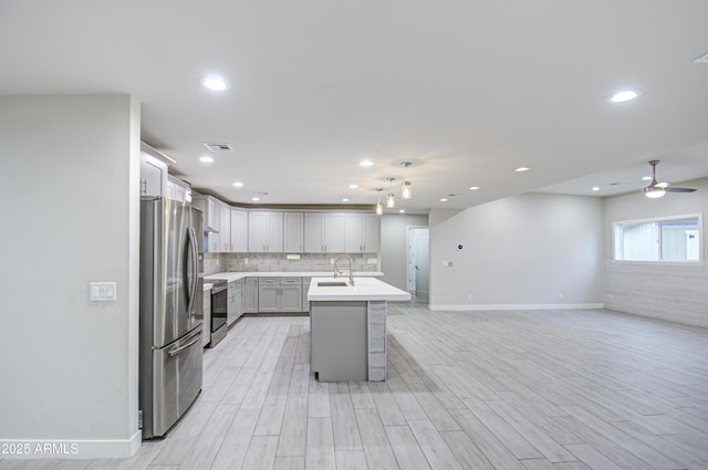 kitchen featuring a sink, visible vents, light countertops, appliances with stainless steel finishes, and backsplash