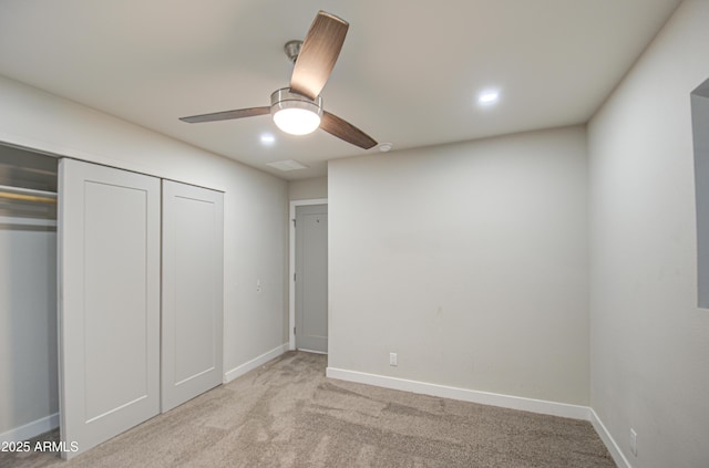 unfurnished bedroom featuring a closet, light colored carpet, visible vents, ceiling fan, and baseboards