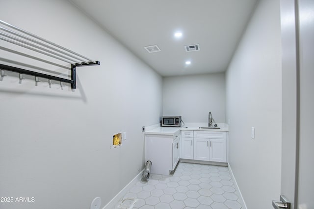 laundry room featuring washer hookup, visible vents, a sink, and baseboards