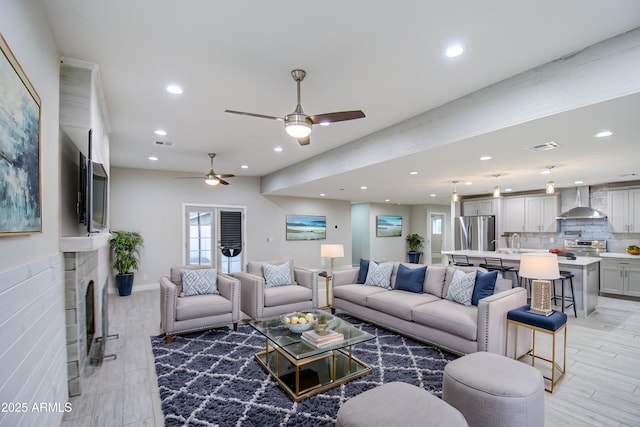 living area featuring recessed lighting, a fireplace, visible vents, and light wood-style floors