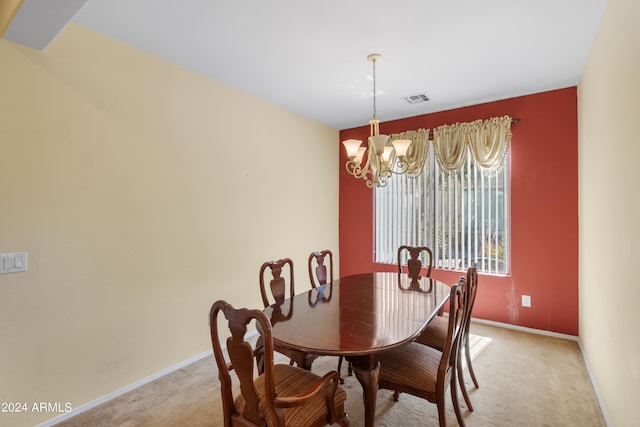 dining space with carpet floors and an inviting chandelier