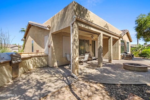 back of house with area for grilling, a fire pit, and a patio area